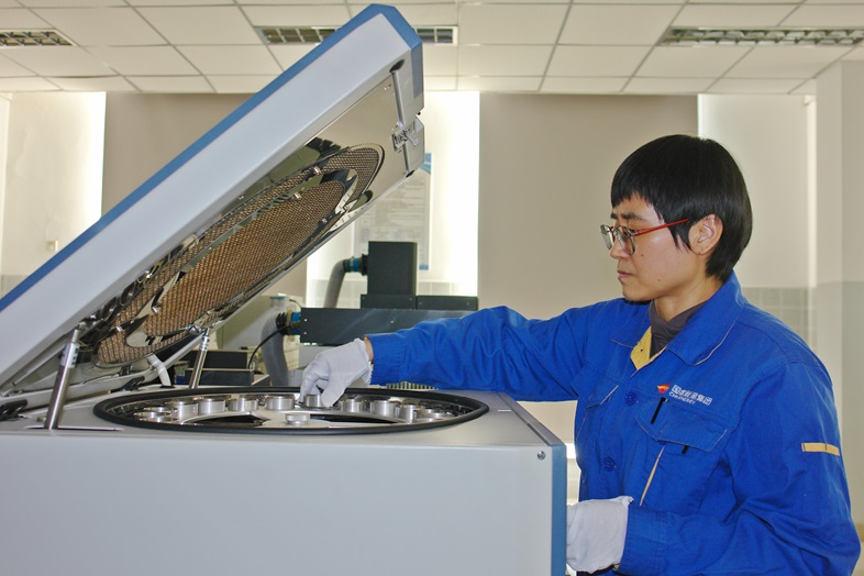 图为包头化工水质环保班组化验员正在检查水分分析仪器内部件.JPG